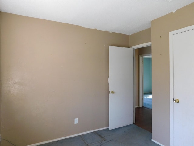 unfurnished room with carpet and baseboards