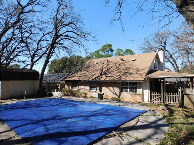 view of swimming pool with a covered pool and fence