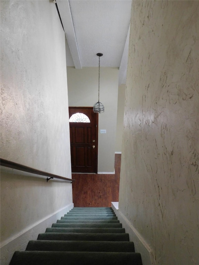 staircase featuring wood finished floors and baseboards