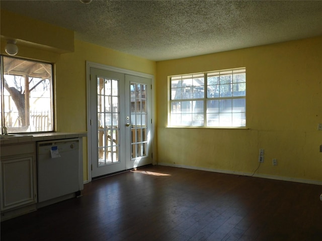 doorway to outside featuring a textured ceiling, french doors, dark wood-type flooring, and a healthy amount of sunlight