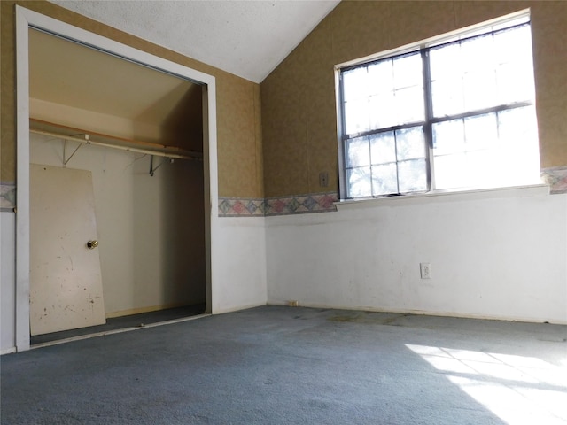 unfurnished bedroom featuring carpet floors, a closet, and vaulted ceiling