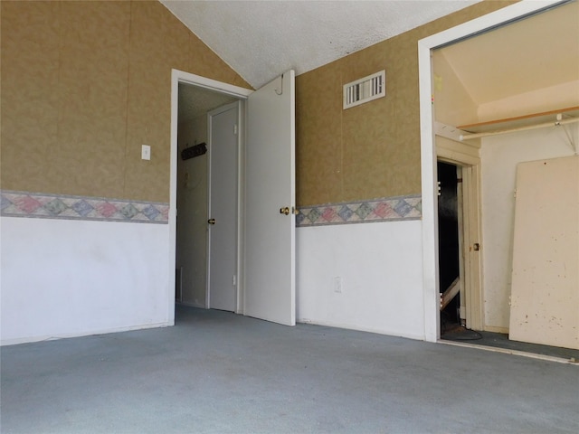 empty room with lofted ceiling and visible vents