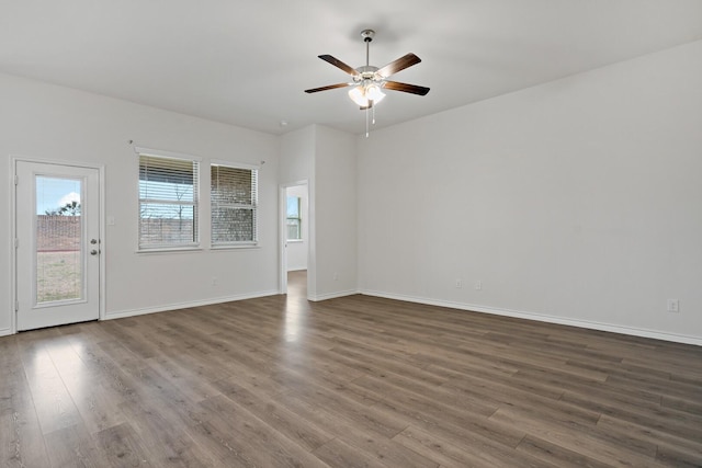 empty room featuring ceiling fan, wood finished floors, and baseboards