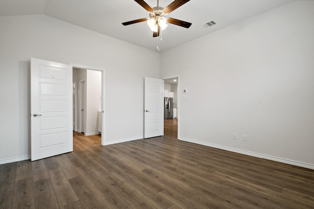 unfurnished bedroom featuring stainless steel fridge, visible vents, dark wood finished floors, baseboards, and lofted ceiling