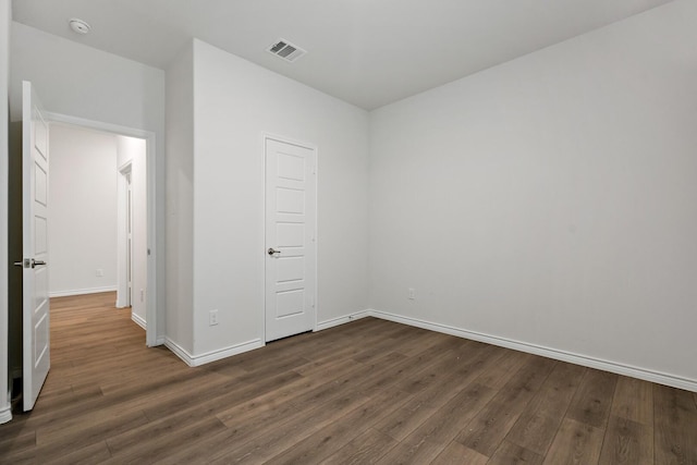 unfurnished bedroom featuring baseboards, visible vents, and dark wood-style flooring