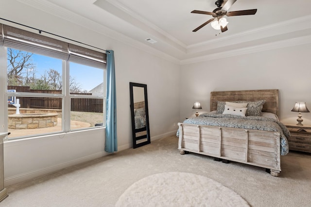 carpeted bedroom with a raised ceiling, visible vents, and crown molding