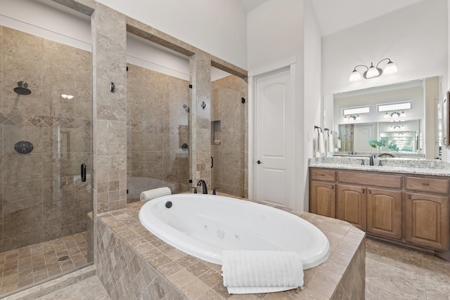 bathroom featuring a stall shower, vanity, and a tub with jets