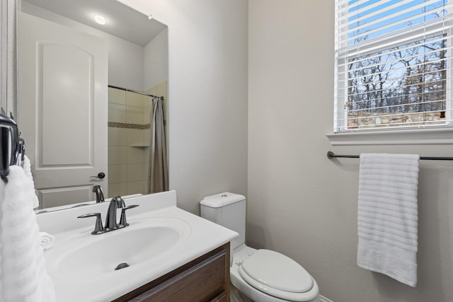 bathroom featuring curtained shower, vanity, and toilet