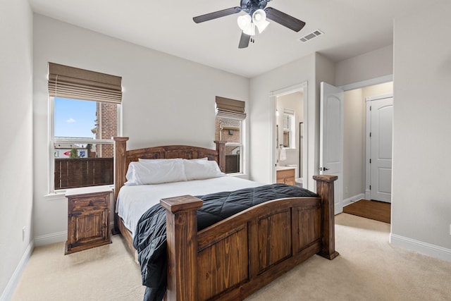 bedroom featuring visible vents, light carpet, baseboards, and ensuite bathroom