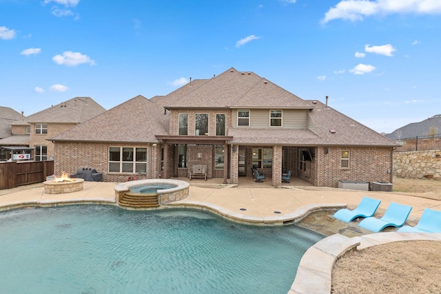 view of pool featuring an outdoor fire pit, a pool with connected hot tub, a patio area, and fence