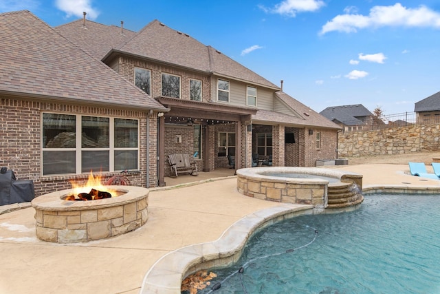 view of swimming pool featuring a fire pit, a patio area, and a pool with connected hot tub