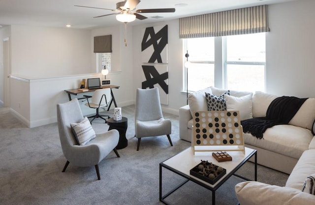 carpeted living area with baseboards and a ceiling fan