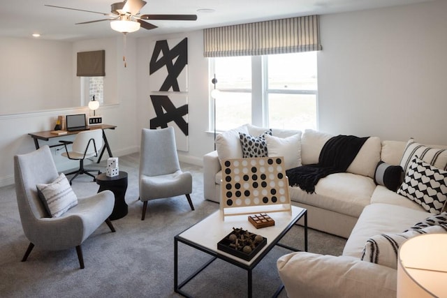 living area featuring carpet floors, baseboards, and a ceiling fan