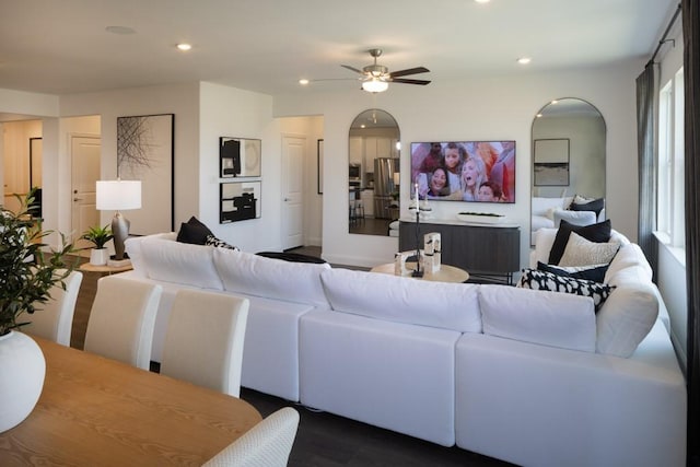 living area with ceiling fan, arched walkways, and recessed lighting