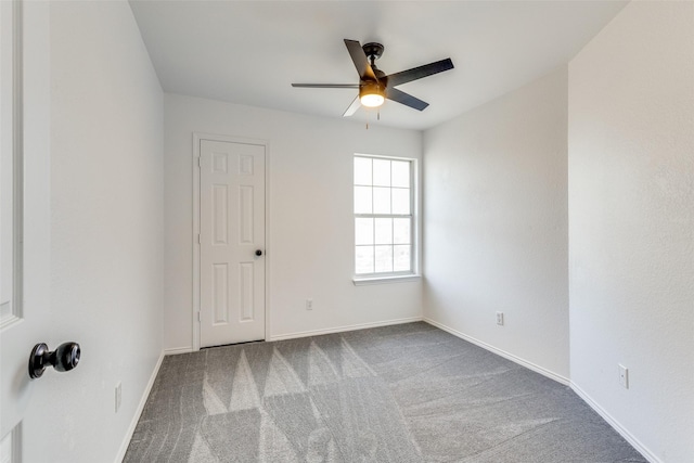 spare room featuring ceiling fan, carpet floors, and baseboards