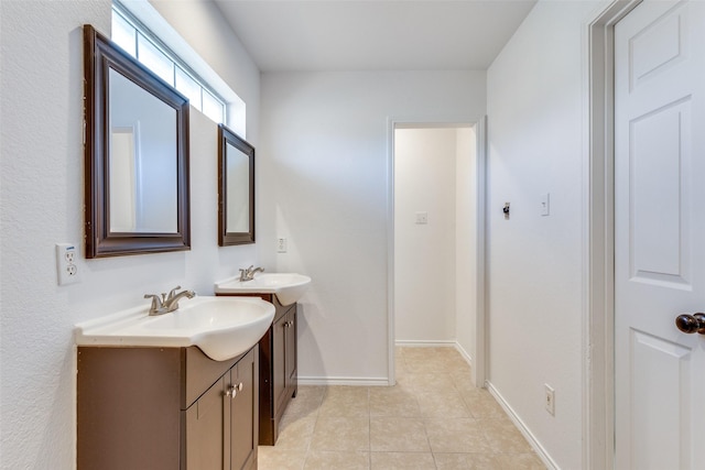 bathroom with two vanities, a sink, baseboards, and tile patterned floors