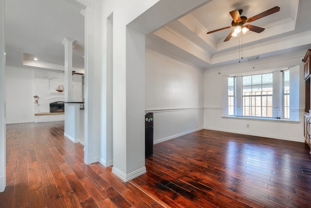 spare room featuring a tray ceiling, dark wood-type flooring, and crown molding