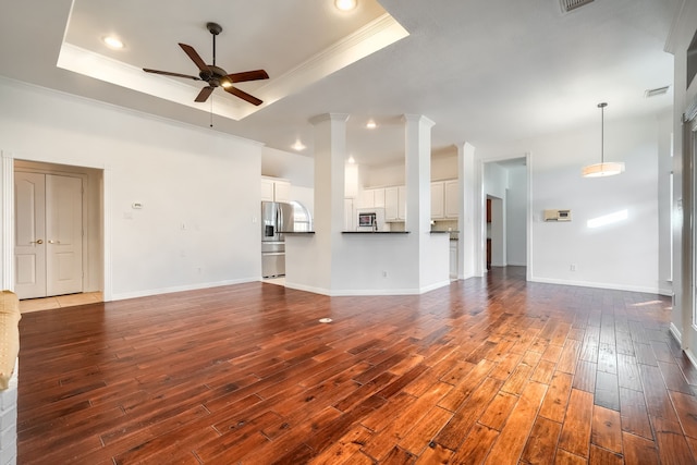 unfurnished living room with decorative columns, a raised ceiling, a ceiling fan, ornamental molding, and dark wood-style flooring