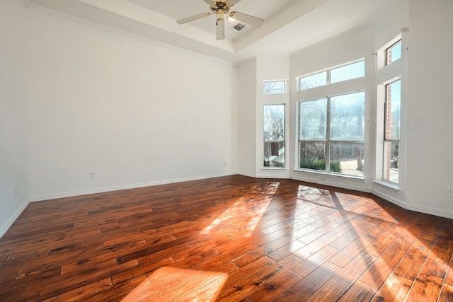 empty room featuring a healthy amount of sunlight, baseboards, and hardwood / wood-style floors