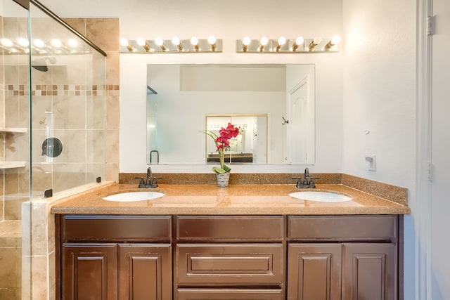 bathroom featuring double vanity, a sink, and a shower stall