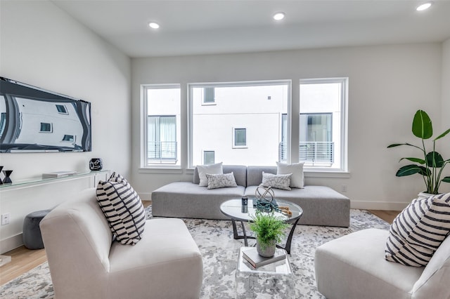 living area with recessed lighting, a healthy amount of sunlight, and wood finished floors