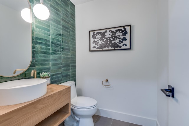 half bath featuring baseboards, toilet, tile patterned flooring, vanity, and tile walls