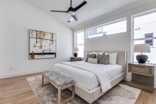 bedroom featuring light wood finished floors, baseboards, visible vents, a ceiling fan, and lofted ceiling