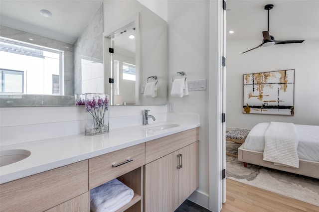 ensuite bathroom featuring wood finished floors, a healthy amount of sunlight, a sink, and connected bathroom