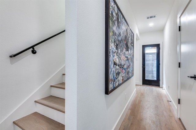 entryway with light wood-style floors, baseboards, stairs, and visible vents