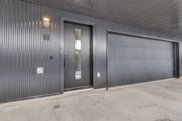 view of exterior entry with a garage and elevator