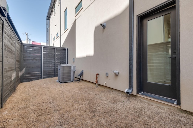 exterior space with central AC and fence