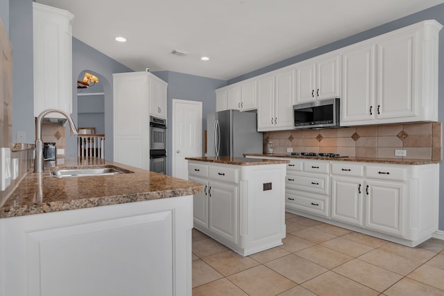 kitchen featuring visible vents, a sink, stainless steel appliances, backsplash, and light tile patterned flooring