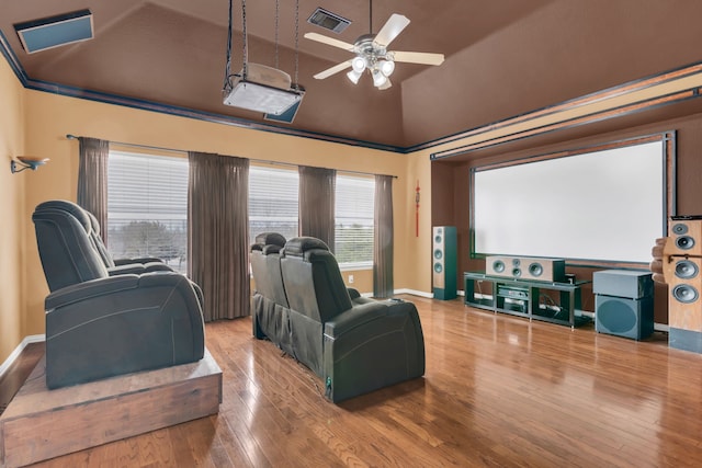 home theater room featuring visible vents, baseboards, wood finished floors, and ceiling fan