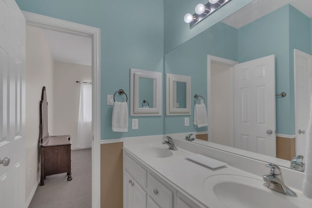 full bathroom with a sink, baseboards, and double vanity