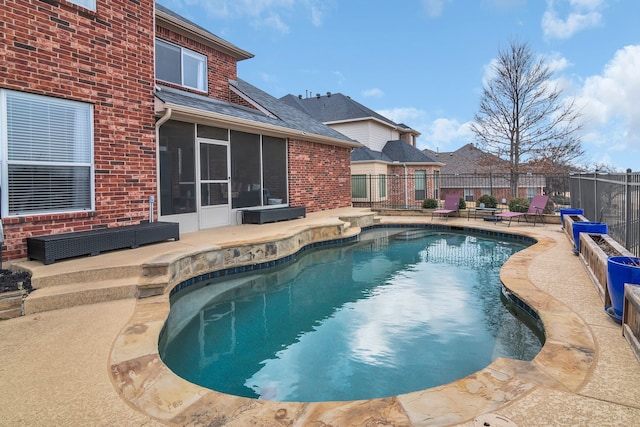 view of pool with fence, a patio area, a sunroom, and a fenced in pool