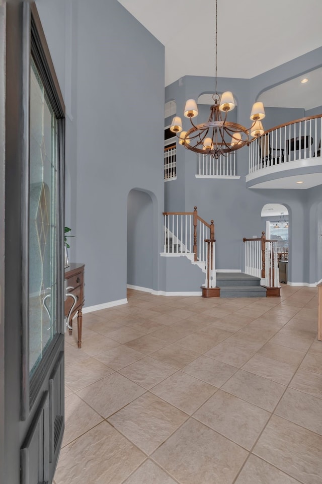 1661 Terrace Dr, Lantana, TX 76226 - foyer entrance featuring arched walkways, a high ceiling, a chandelier, stairway, and light tile patterned floors