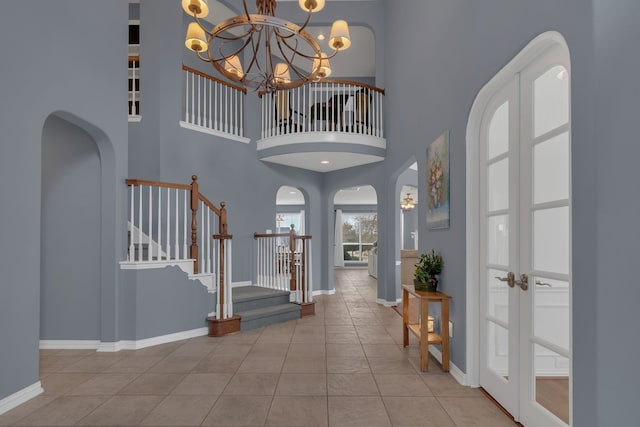 1661 Terrace Dr, Lantana, TX 76226 - foyer featuring a chandelier, arched walkways, tile patterned flooring, baseboards, and a towering ceiling