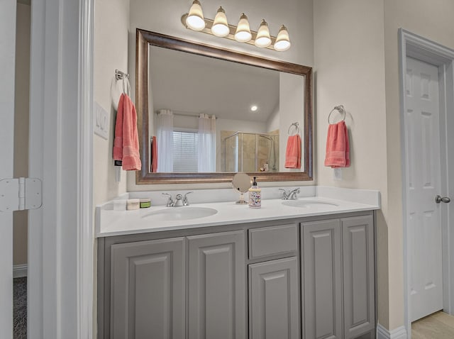 bathroom with double vanity, a stall shower, and a sink