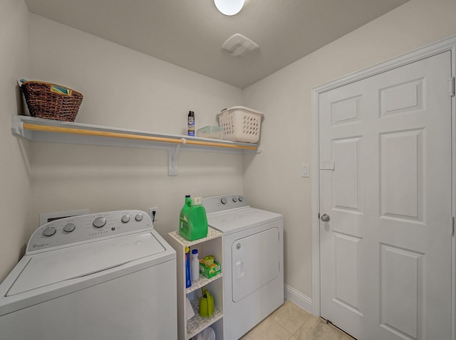 laundry area with light tile patterned floors, visible vents, baseboards, washing machine and clothes dryer, and laundry area