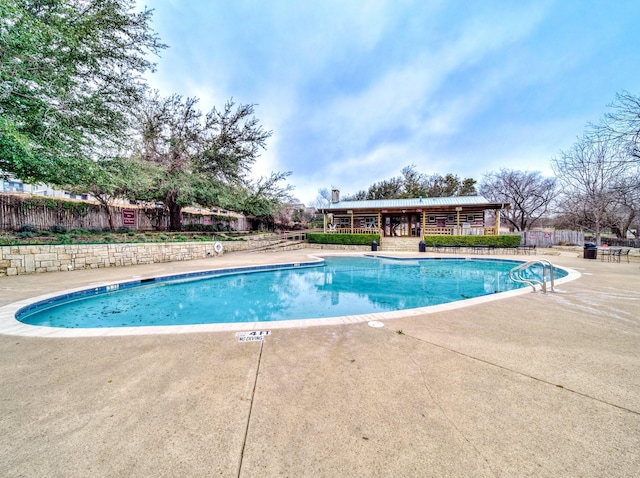 pool featuring a patio area and fence