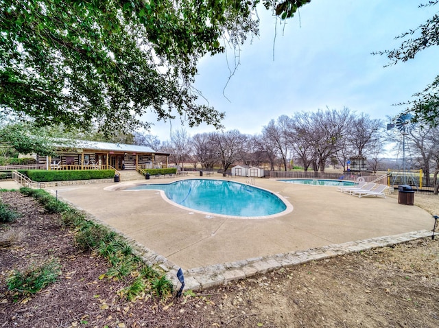 pool featuring a patio area and fence