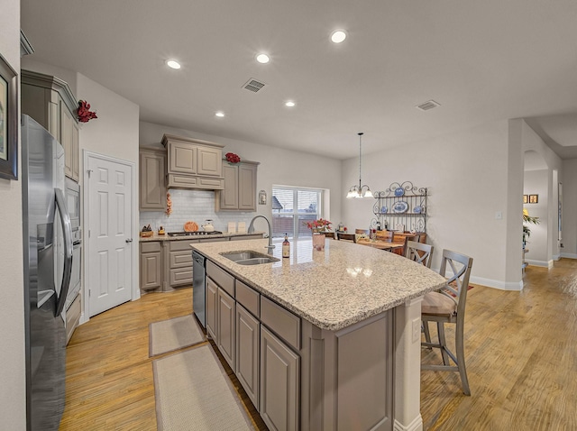 kitchen with visible vents, gray cabinets, stainless steel appliances, and a sink