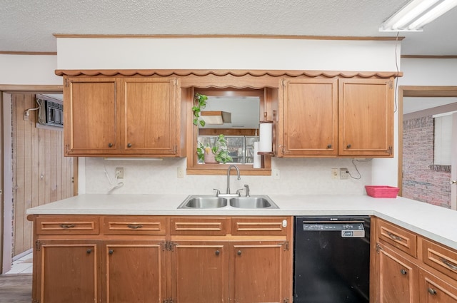 kitchen featuring black dishwasher, a textured ceiling, light countertops, and a sink