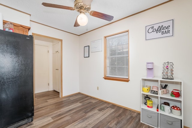 rec room with crown molding, a textured ceiling, baseboards, and wood finished floors