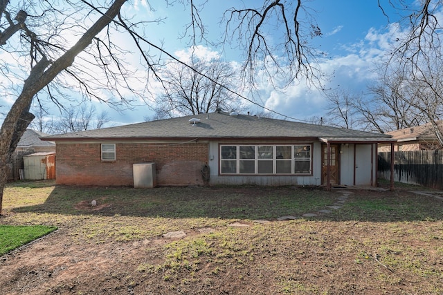 back of property with brick siding and fence