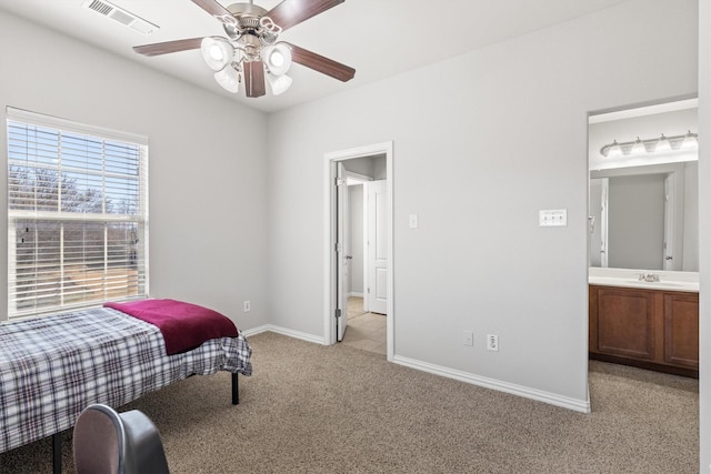 bedroom featuring light colored carpet, visible vents, a ceiling fan, a sink, and baseboards