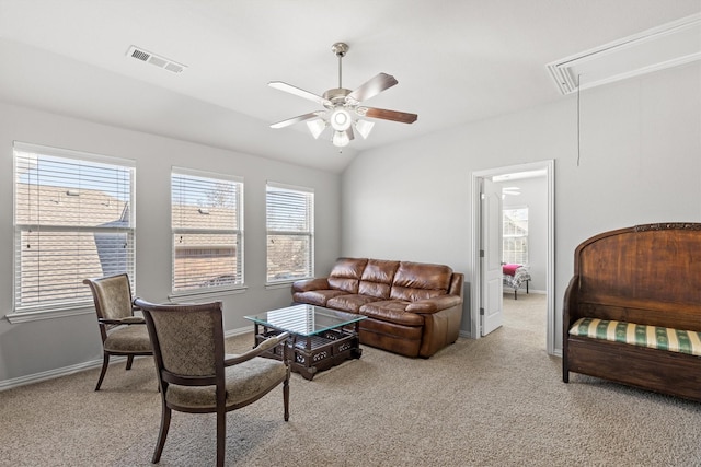 living area with attic access, visible vents, vaulted ceiling, and light carpet