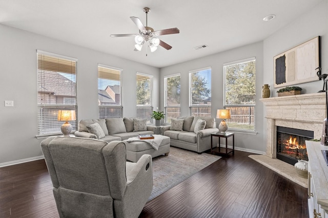 living area featuring dark wood-style flooring, visible vents, a fireplace, and baseboards