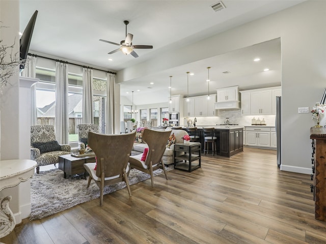 living area with dark wood-type flooring, recessed lighting, visible vents, and a ceiling fan