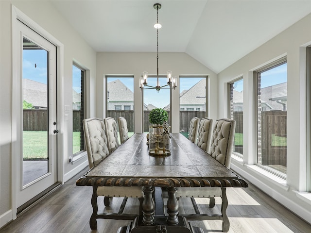 dining room with baseboards, dark wood-type flooring, a wealth of natural light, and an inviting chandelier